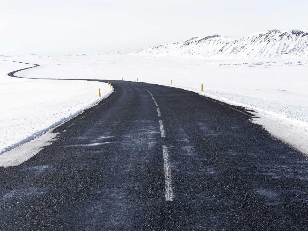 Carretera curvando entre campos nevados